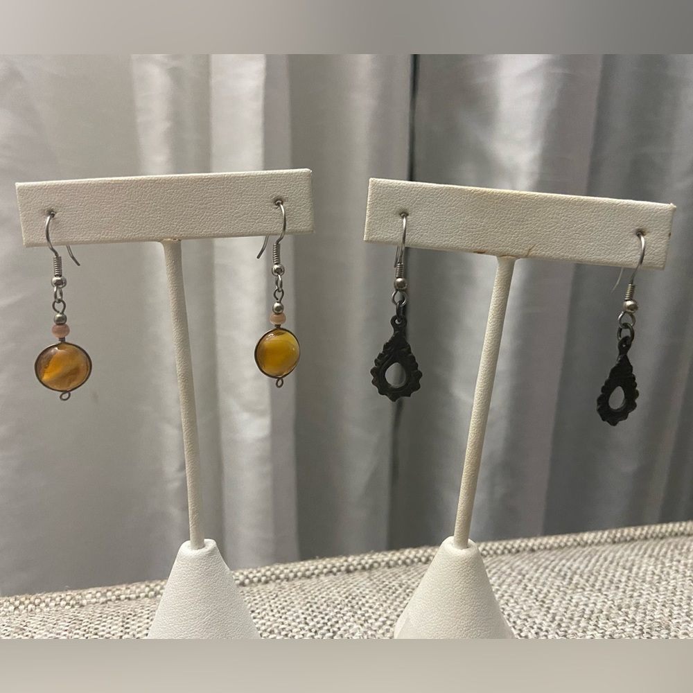 Three pair of earrings: peach, brown/bronze and silver skulls.